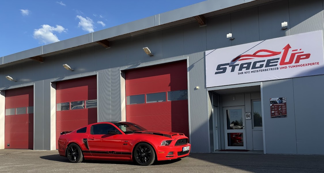 Werkstatt von StageUp in Bargau mit rotem Ford Mustang vor den Hallentoren